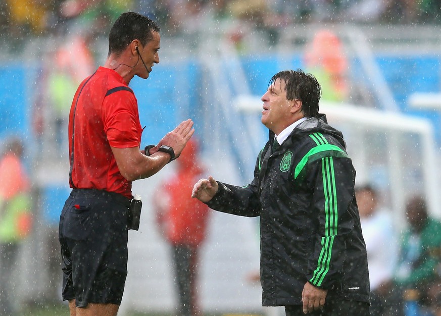 Schiedsrichter Wilmar Roldan versucht, Mexikos Trainer Miguel Herrera zu beruhigen.