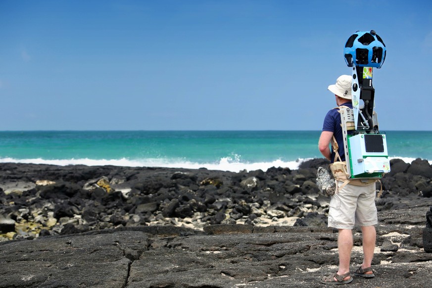 In this May 2013 photo provided by Google, Daniel Orellana of the Charles Darwin Foundation collects seashore imagery with the Street View Trekker at the Los Humedales wetland area on Isabela Island i ...