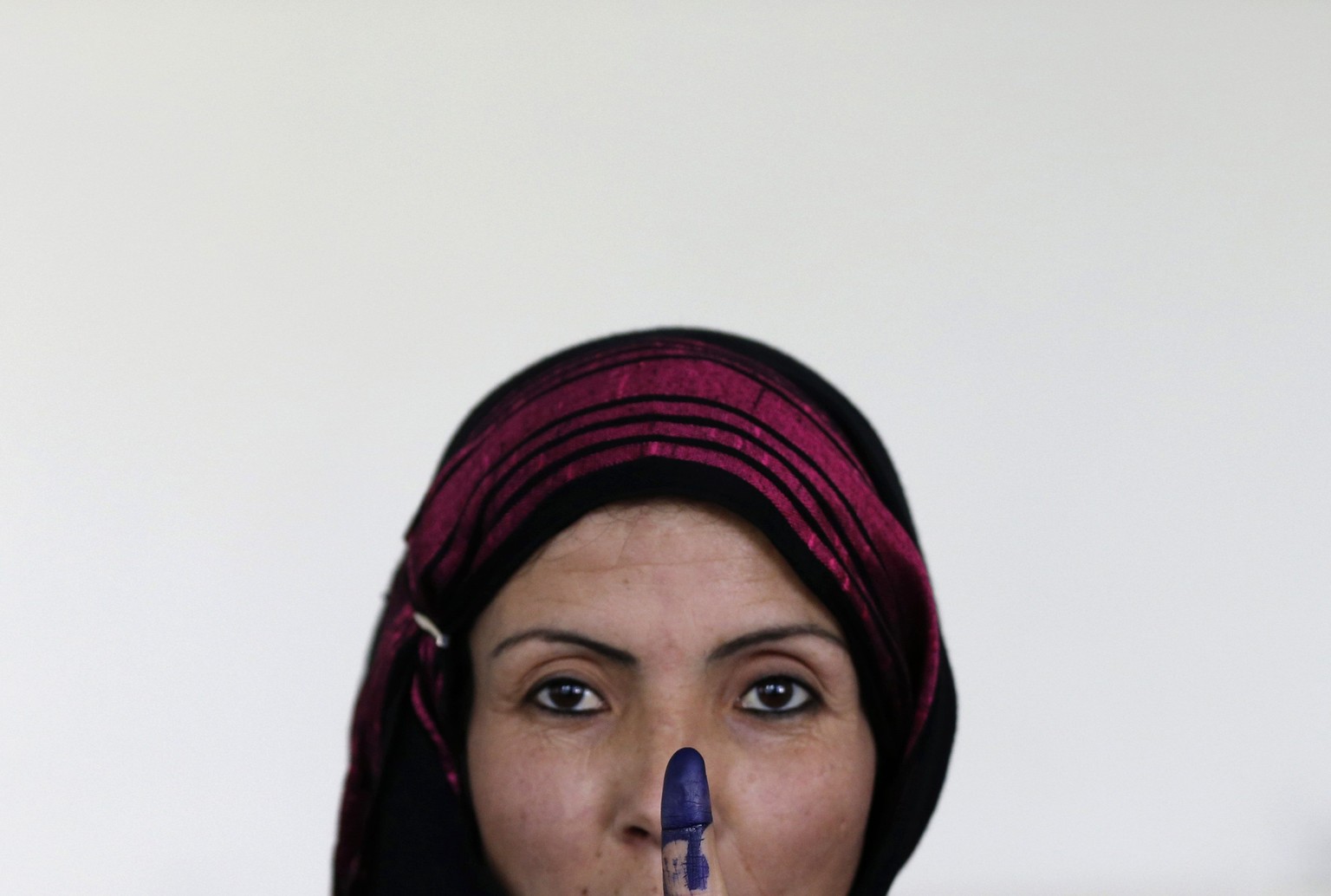 Eine Frau in Kabul hält ihren mit Tinte verschmierten Finger in die Höhe, nachdem sie gewählt hat.