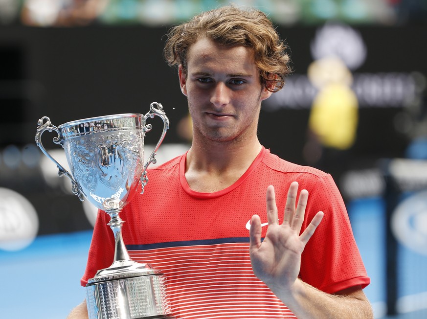 Oliver Anderson of Australia holds his trophy after defeating Jurabeck Karimov of Uzbekistan in the boy&#039;s singles final at the Australian Open tennis championships in Melbourne, Australia, Saturd ...