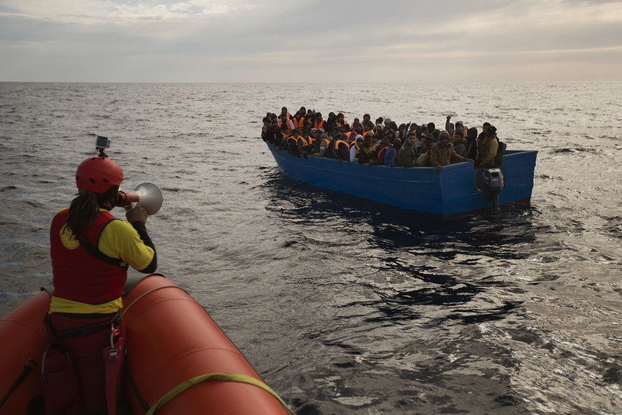 Migrants and refugees are assisted by members of the Spanish NGO Proactiva Open Arms, as they crowd aboard a boat sailing out of control in the Mediterranean Sea about 21 miles north of Sabratha, Liby ...