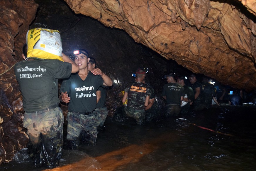 epa06858272 An undated handout photo released by Royal Thai Army on 02 July 2018 shows Thai soldiers carrying equipments inside the flooded cave complex during a rescue operation for a missing youth s ...