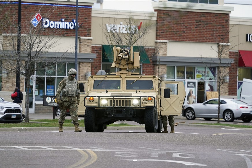 A National Guard soldier maintain watch and directs traffic at a shopping center in Brooklyn Center, Minn., a suburb of Minneapolis, Monday, April 12, 2021. A Black man died after being shot by police ...