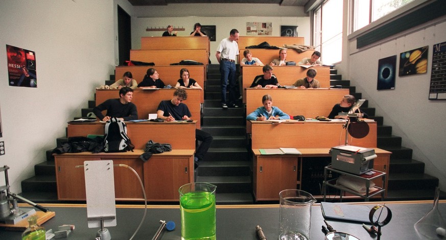 Der Physiklehrer des Mathematisch-Naturwissenschaftlichen Gymnasiums Raemibuehl in Zuerich, kontrolliert die Notizen der Schueler waehrend des Unterrichts, aufgenommen am 1. Juni 2004. Auf dem Tisch l ...