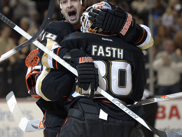 Anaheim Ducks goalie Viktor Fasth, right, of Sweden, celebrates his game-winning save with defenseman Sheldon Souray, center, and defenseman Cam Fowler during the third period of their NHL hockey game ...