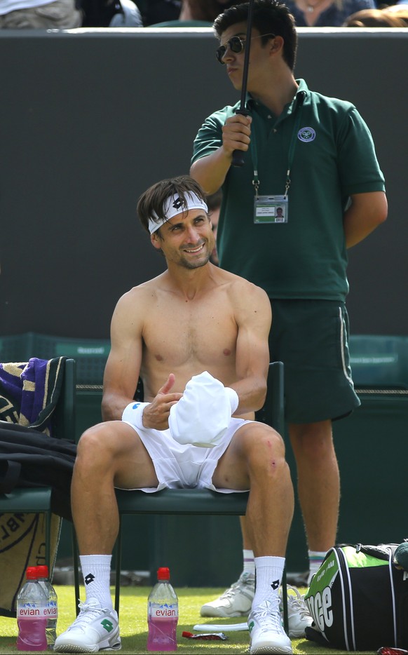 David Ferrer of Spain changes his shirt between games against Andrey Kuznetsov of Russia during their men&#039;s singles match at the All England Lawn Tennis Championships in Wimbledon, London, Wednes ...