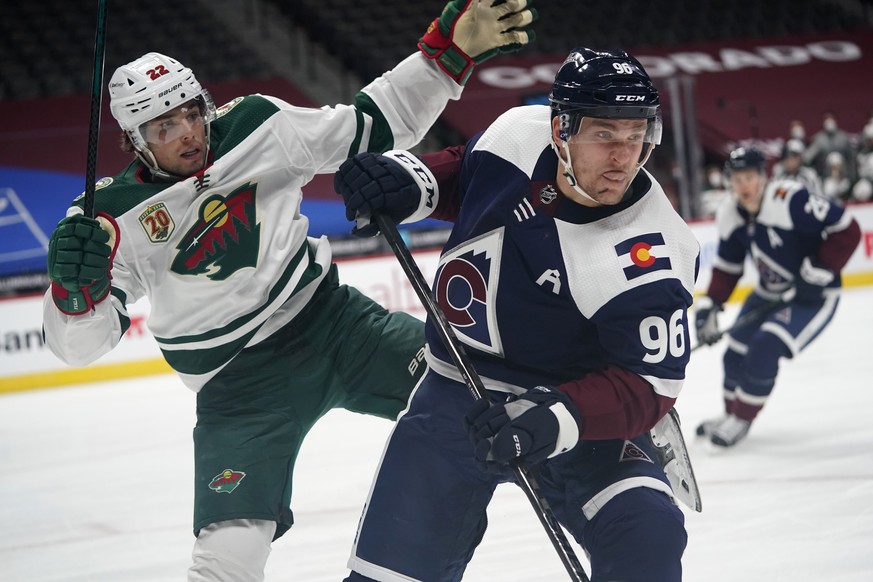 Colorado Avalanche right wing Mikko Rantanen, front, fends off Minnesota Wild left wing Kevin Fiala as they pursue the puck in the second period of an NHL hockey game Wednesday, Feb. 24, 2021, in Denv ...