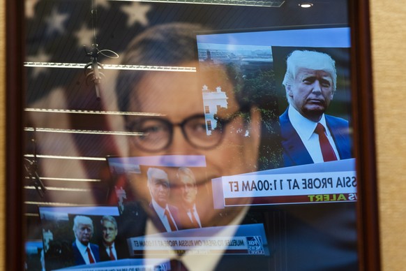 epa07610307 TV news images are reflected in a portrait of Attorney General Robert Barr at the Justice Department in Washington, DC, USA, 29 May 2019. Special Counsel Robert Mueller is expected to spea ...
