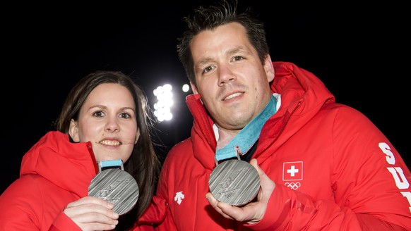 Jenny Perret, left, and Martin Rios, right, of Switzerland pose with their silver medals at the House of Switzerland after the victory ceremony of the curling mixed doubles at the XXIII Winter Olympic ...