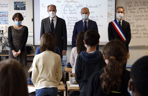 French Prime Minister Jean Castex, second left, and Education Minister Jean-Michel Blanquer, second right, observe a minute of silence for slain history teacher Samuel Paty, Monday Nov. 2, 2020 at a s ...