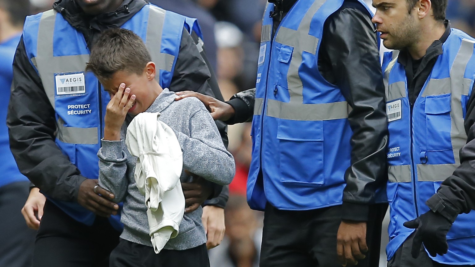 Security guards escort a crying boy who is holding the shirt PSG&#039;s Neymar gave him after he ran onto the pitch at the end of the French League One soccer match between Rennes and Paris-Saint-Germ ...