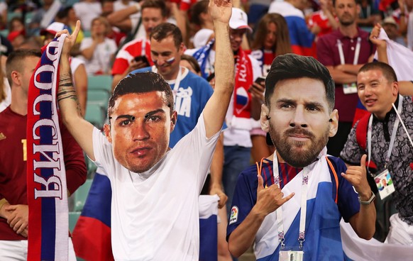 epa06872036 Supporters of Russia wear face masks depicting Cristiano Ronaldo (L) of Portugal and Lionel Messi (R) of Argentina prior to the FIFA World Cup 2018 quarter final soccer match between Russi ...