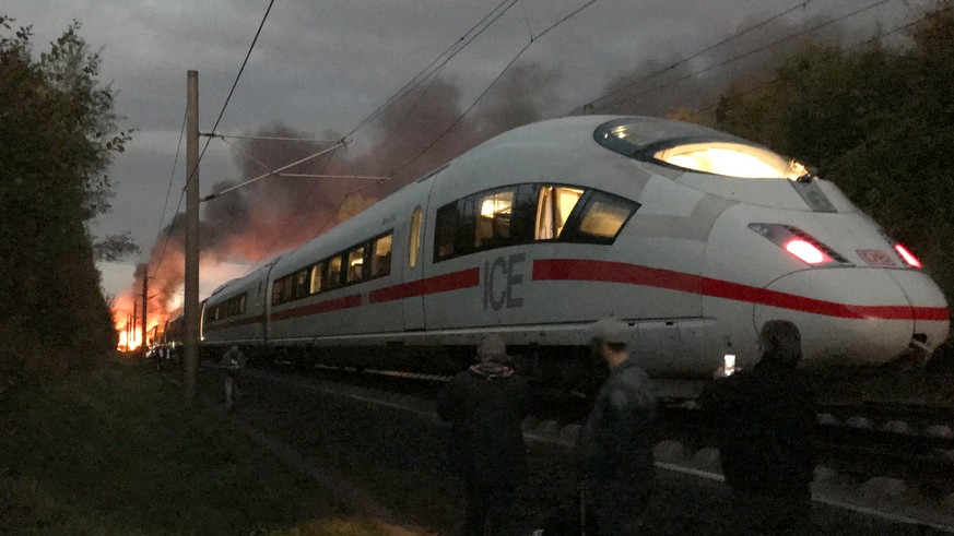 epa07088022 Flames and smoke billowing from a coach of an Inter City Express (ICE) train can be seen in this picture taken by a passenger during the evacuation of the train in the area of Diedorf, nea ...
