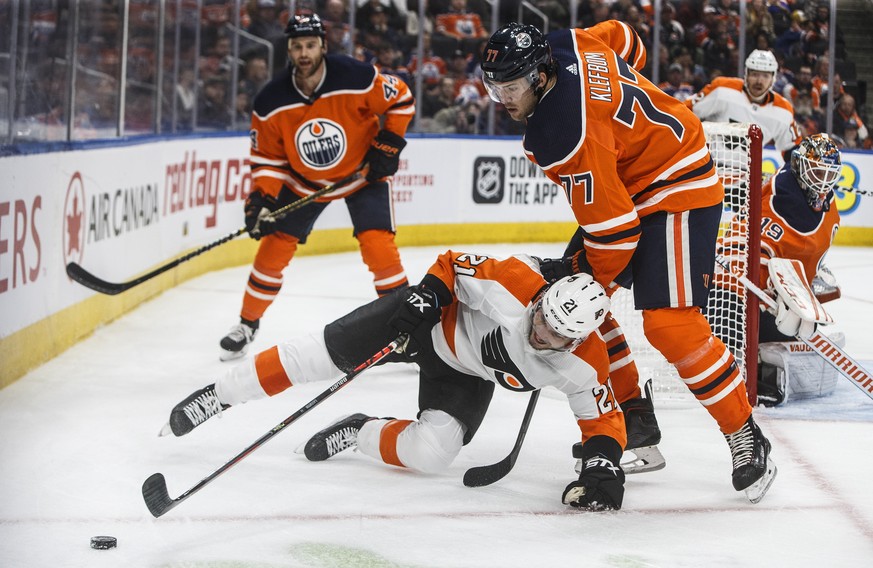 Philadelphia Flyers&#039; Scott Laughton (21) is tripped by Edmonton Oilers&#039; Oscar Klefbom (77) during the first period of an NHL hockey game Wednesday, Oct. 16, 2019, in Edmonton, Alberta. (Jaso ...