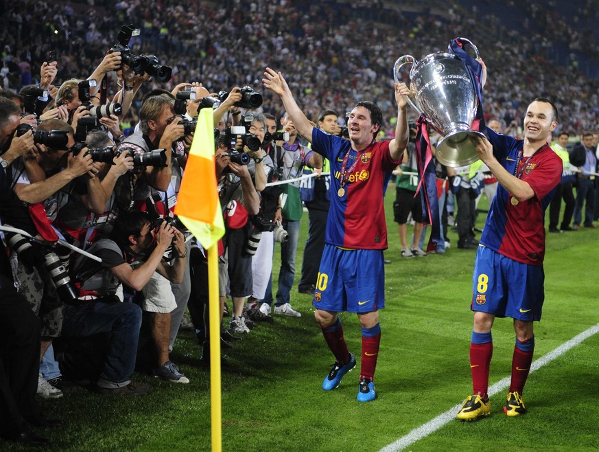 Barcelona&#039;s Andres Iniesta, right, and Lionel Messi hold the trophy at the end of the UEFA Champions League final soccer match between Manchester United and Barcelona in Rome, Wednesday May 27, 2 ...