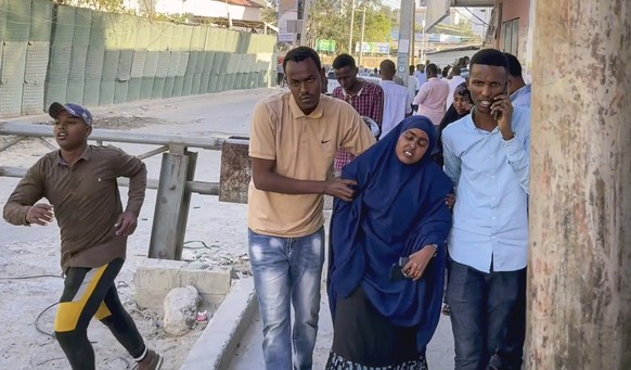 In this image made from video, people flee from the area as gunshots are heard, on a street near the Afrik hotel in the capital Mogadishu, Somalia Sunday, Jan. 31, 2021. The hotel in Somalia&#039;s ca ...