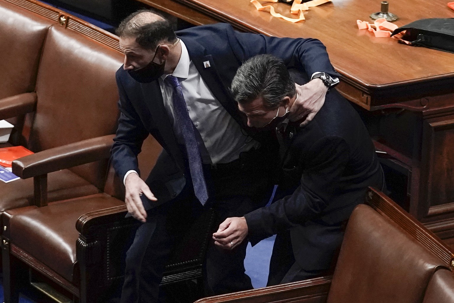 House of Representatives members leave the floor of the House chamber as protesters try to break into the chamber at the U.S. Capitol on Wednesday, Jan. 6, 2021, in Washington. (AP Photo/J. Scott Appl ...