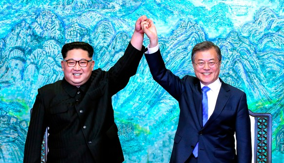 FILE - In this April 27, 2018 file photo, North Korean leader Kim Jong Un, left, and South Korean President Moon Jae-in raise their hands after signing a joint statement at the border village of Panmu ...