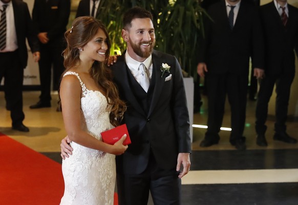 epa06058885 Argentinian soccer player Lionel Messi (R) and his wife Antonella Roccuzzo (L), pose for the media after their wedding in Rosario, Santa Fe, Argentina, 30 June 2017. EPA/David Fernandez
