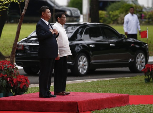 epa07178905 Chinese President Xi Jinping (L) and Philippine President Rodrigo Duterte (R) stand on a platform as Xi&#039;s official car passes from behind during a welcome ceremony at the Malacanang P ...