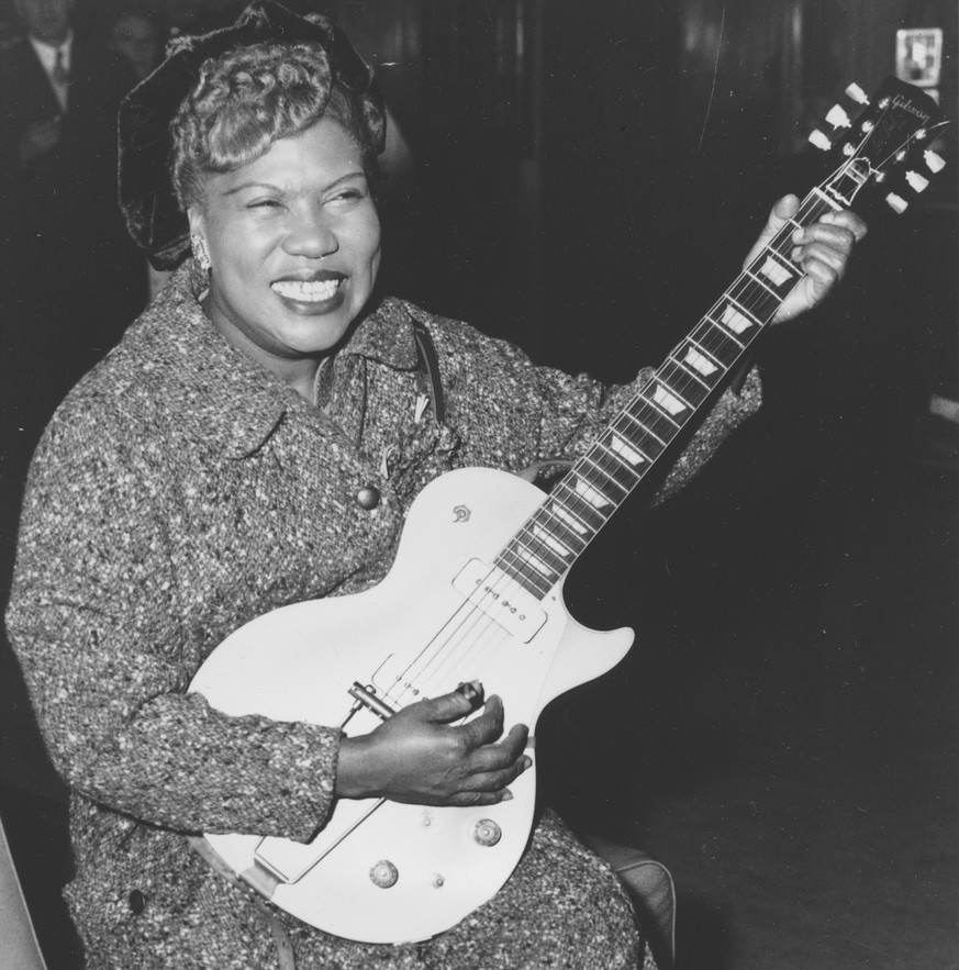 FILE- In this Nov. 21, 1957, file photo, Sister Rosetta Tharpe, guitar-playing American gospel singer, gives an inpromptu performance in a lounge at London Airport, following her arrival from New York ...