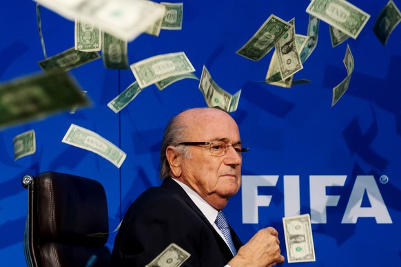 FILE - FIFA Suspend President Sepp Blatter, Michel Platini And Jerome Valcke ZURICH, SWITZERLAND - JULY 20: Comedian Simon Brodkin (not pictured) throws dollar bills at FIFA President Joseph S. Blatte ...