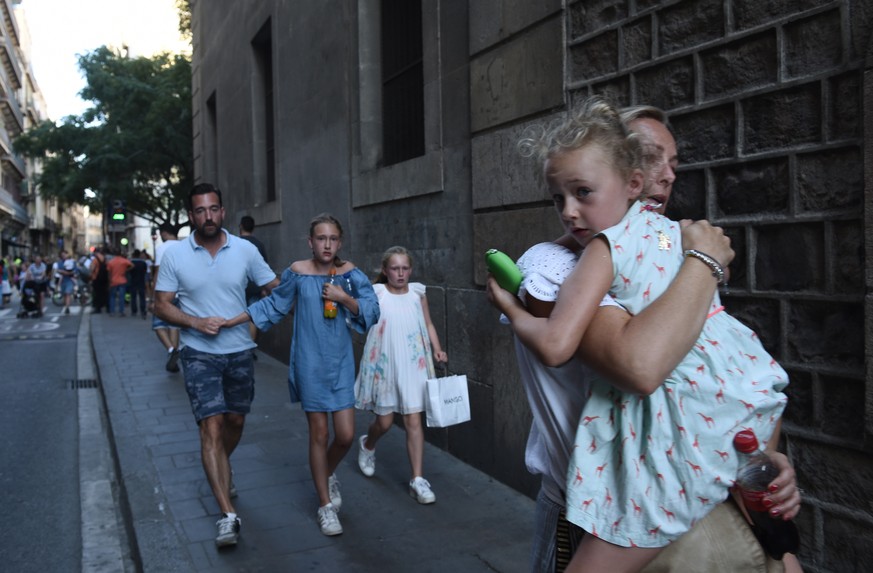 People flee the scene in Barcelona, Spain, Thursday, Aug. 17, 2017 after a white van jumped the sidewalk in the historic Las Ramblas district, crashing into a summer crowd of residents and tourists an ...