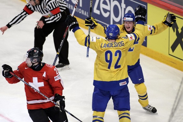 Sweden&#039;s Simon Hjalmarsson, right, celebrates his goal with teammate Gabriel Landeskog, centre, behind Switzerland&#039;s Martin Pluess, left, after scored the 1:3, during the the Gold Medal game ...