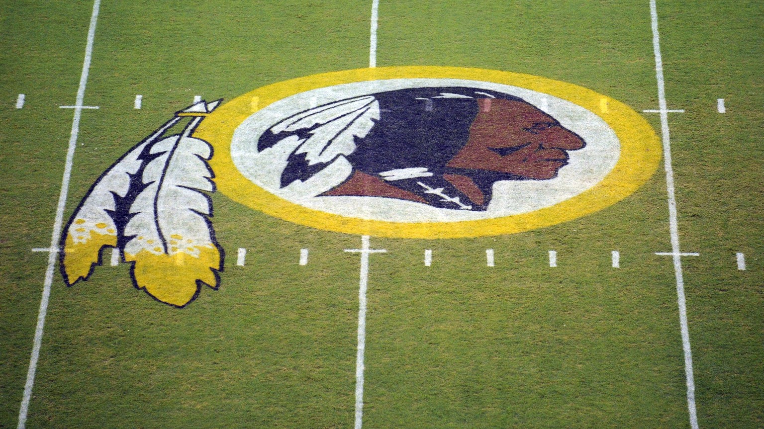 FILE - In this Aug. 28, 2009 file photo, the Washington Redskins logo is shown on the field before the start of a preseason NFL football game against the New England Patriots in Landover, Md. The Wash ...