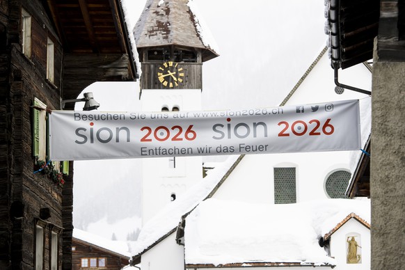 THEMENBILD ZUR ABSTIMMUNG WALLIS UEBER OLYMPIA KANDIDATUR SION 2026 --- Une banderole pour la candidature de Sion 2026 pour les Jeux Olympiques d&#039;hiver est visible entre des chalets a Muenster ce ...