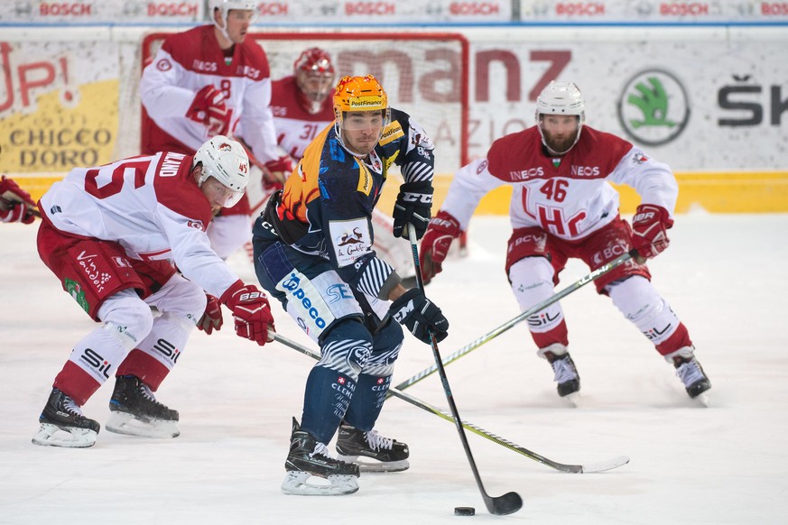 Lausanne&#039;s player Jonas Junland, Ambri&#039;s player Matt D&#039;Agostini and Lausanne&#039;s player Benjamin Antonietti, from left, fight for the puck, during the preliminary round game of the N ...