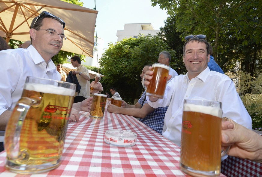 O&#039;zapft is.... SP Parteipraesident Christian Levrat , rechts, und Michael Braendli, links, persoenlicher Mitarbeiter von Bundesrat Alain Berset, links, mit einem kuehlen Bier beim Besuch der Brau ...
