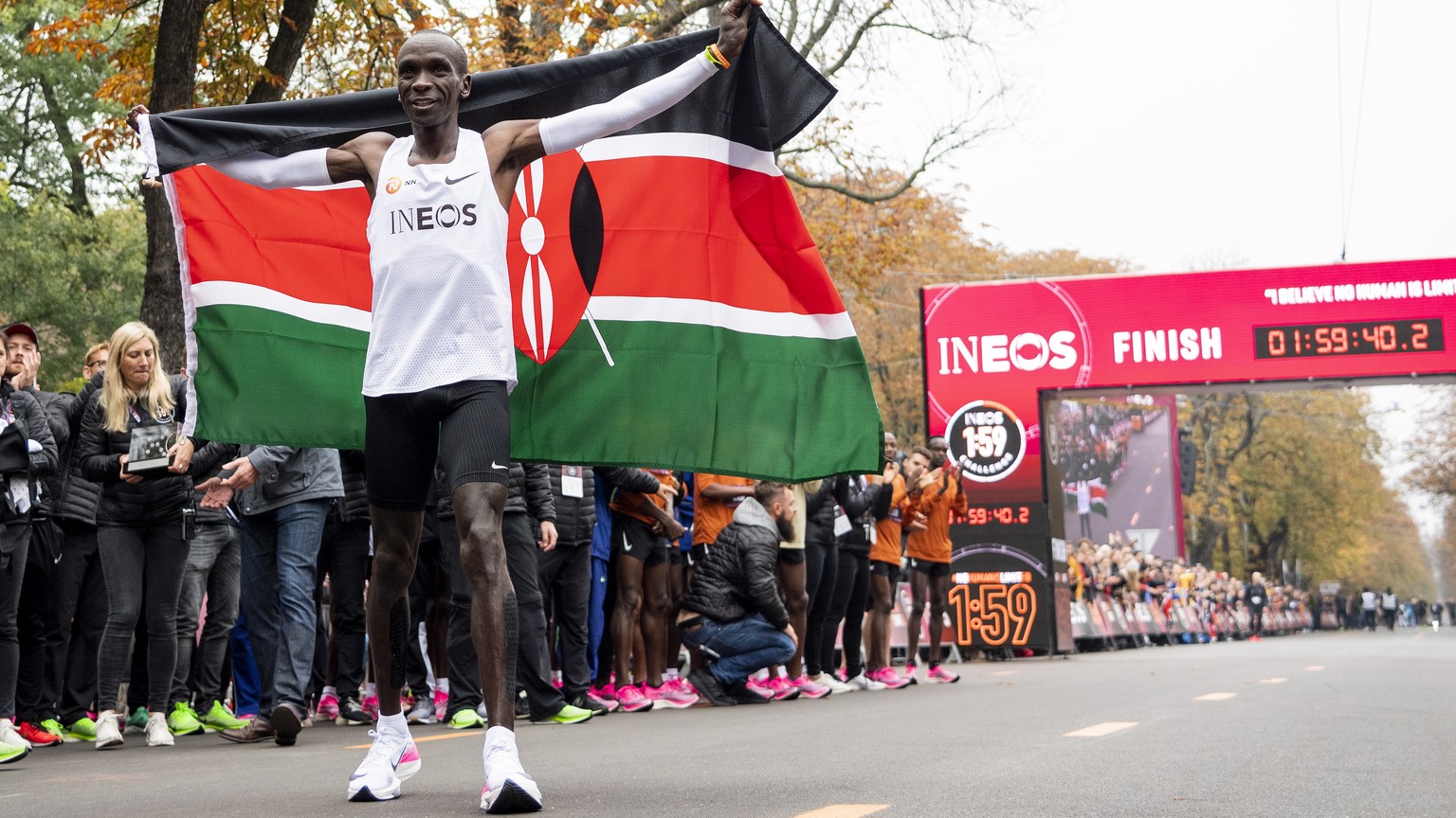 epa07914793 Eliud Kipchoge, Kenyan marathon world record holder, celebrates with the flag of Kenya in front of the finish line after the INEOS 1:59 Challenge in Vienna, Austria, 12 October 2019. Kipch ...