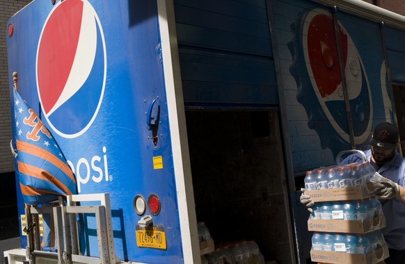FILE- In this May 7, 2018, file photo a delivery man unloads cases of soft drinks from a Pepsi truck in New York. PepsiCo Inc. reports earns on Friday, Feb. 15, 2019. (AP Photo/Mark Lennihan, File)