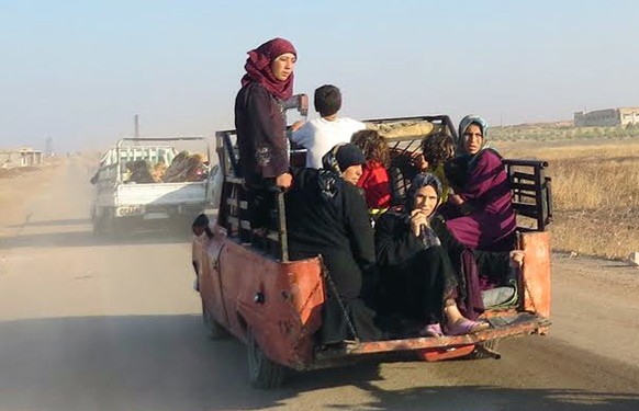 This photo provided by the Syria Press Center (SPC), an anti-government media group, shows civilians leaving the town of Suran, in Hama province, Syria, Thursday Sept. 1, 2016. Suspected government wa ...