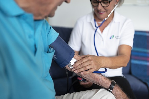 An employee of Spitex (division Thun) measures a client&#039;s blood pressure und pulse, at his home in Thun, in the Canton of Bern, Switzerland, on September 16, 2019. (KEYSTONE/Gaetan Bally)

Eine S ...