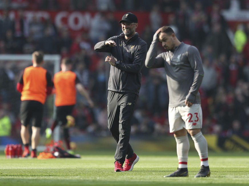 Liverpool manager Juergen Klopp smiles next to Liverpool&#039;s Xherdan Shaqiri prior to the English Premier League soccer match between Manchester United and Liverpool at Old Trafford stadium in Manc ...