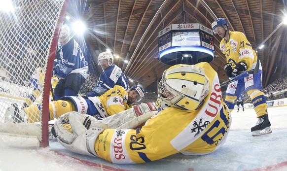 Minsk&#039;s Evgeny Kovyrshin and Rob Klinkhammer fight for the puck with Davos&#039; Beat Forster, goalkeeper Melvin Nyffeler, and Per Ledin, from left, during the game between HK Dinamo Minsk and HC ...