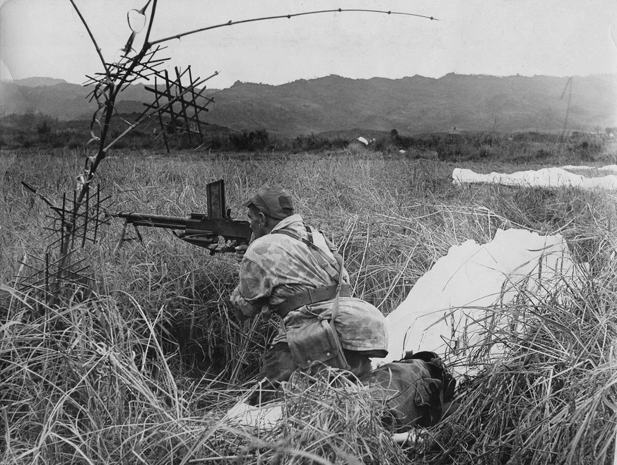 With his parachute lying beside him, a French paratrooper mans his automatic weapon during the &quot;Operation Castor&quot; attack on Dien Bien Phu, Indochina, Nov. 20, 1953. Several thousand French a ...