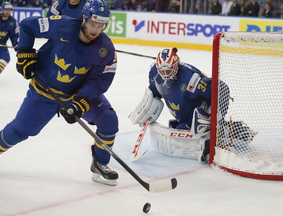 Sweden defender Niclas Andersen removes the puck in front of Sweden goaltender Anders Nilsson during a semifinal match between Russia and Sweden at the Ice Hockey World Championship in Minsk, Belarus, ...