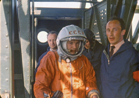 In this April 12 1961 photo, rocket engineer Oleg Ivanovsky, right, leads Yuri Gagarin, center, to the Vostok spacecraft before the launch from what will later become known as the Baikonur cosmodrome. ...