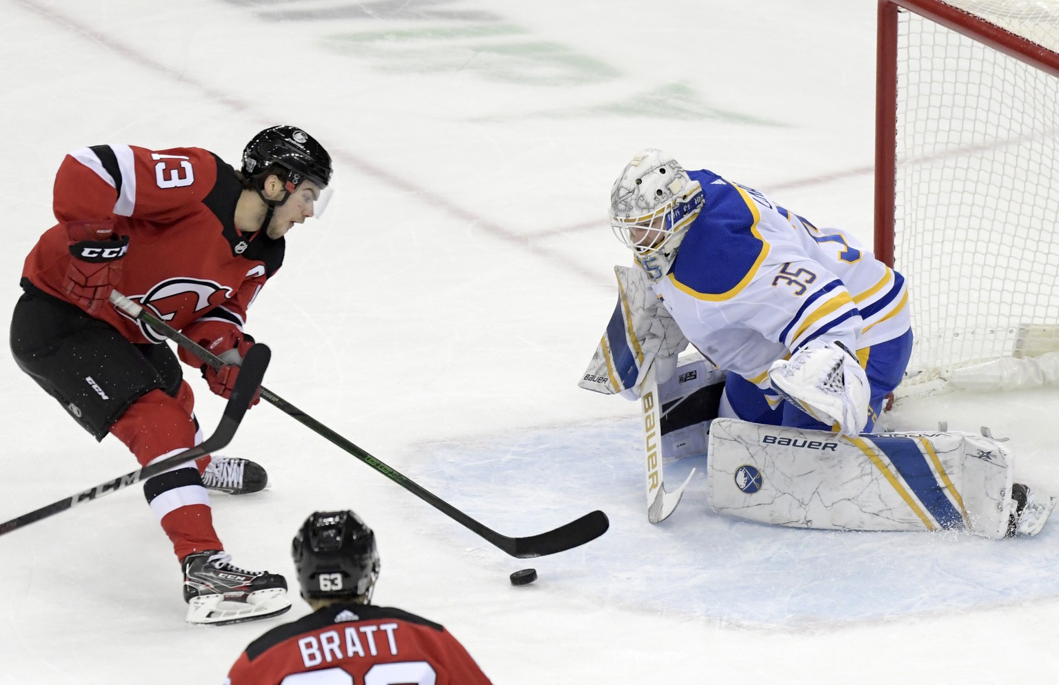 New Jersey Devils center Nico Hischier (13) skates in on Buffalo Sabres goaltender Linus Ullmark (35) during the second period of an NHL hockey game Tuesday, Feb. 23, 2021, in Newark, N.J. (AP Photo/B ...