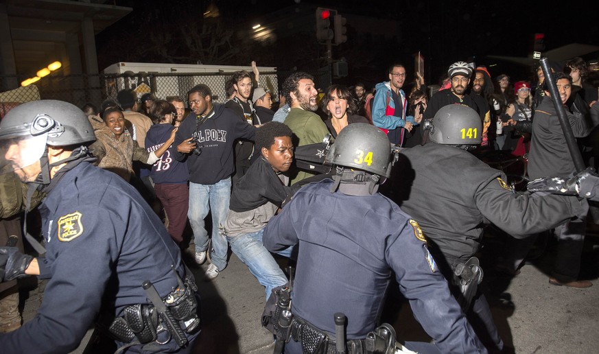 Police officers scuffle with protesters during a protest against police violence in the U.S., in Berkeley, California December 6, 2014. More than five police vehicles suffered damage as several hundre ...