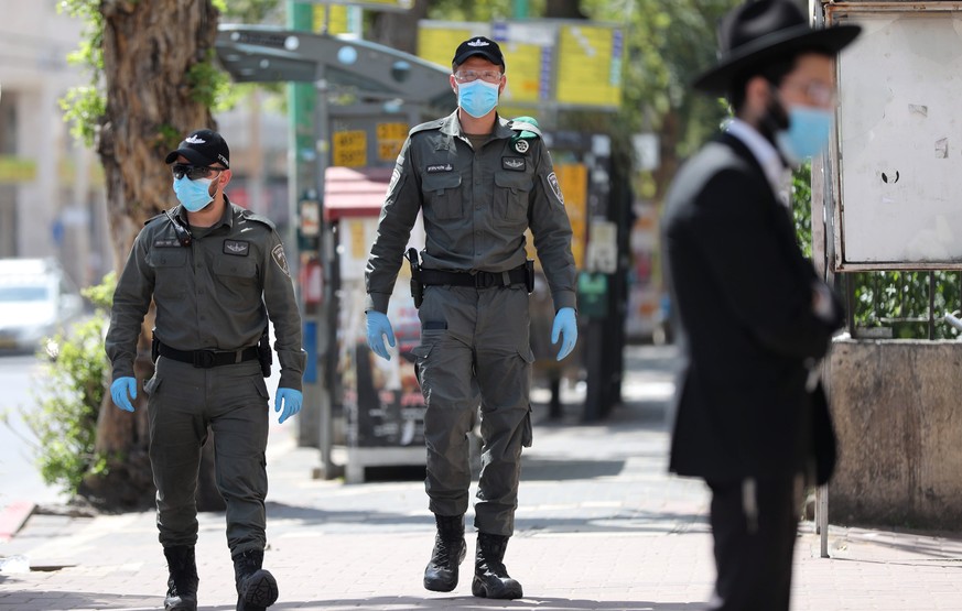 epa08340688 Israeli Border Police wearing protective face masks as they patrol an empty main street in the city of Bnei Brak , Israel, 03 April 2020. The media report that Israeli Police have closed t ...