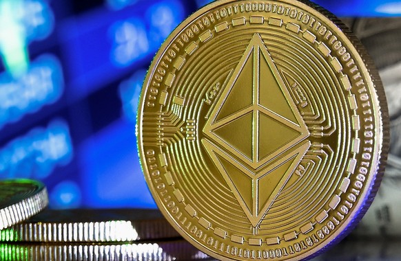 epa08951383 An Ethereum coin in front of a monitor showing a stock barometer in Duesseldorf, Germany, 20 January 2021. Cryptocurrency Bitcoin has experienced drastic ups and downs in recent weeks and  ...
