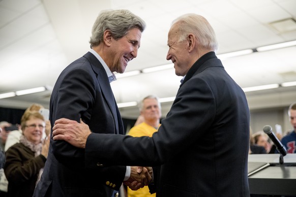 FILE - In this Feb. 1, 2020, file photo Democratic presidential candidate former Vice President Joe Biden smiles as former Secretary of State John Kerry, left, takes the podium to speak at a campaign  ...