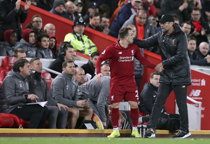 Liverpool manager Jurgen Klopp, right, salutes Liverpool midfielder Xherdan Shaqiri during the English Premier League soccer match between Liverpool and Everton at Anfield Stadium in Liverpool, Englan ...