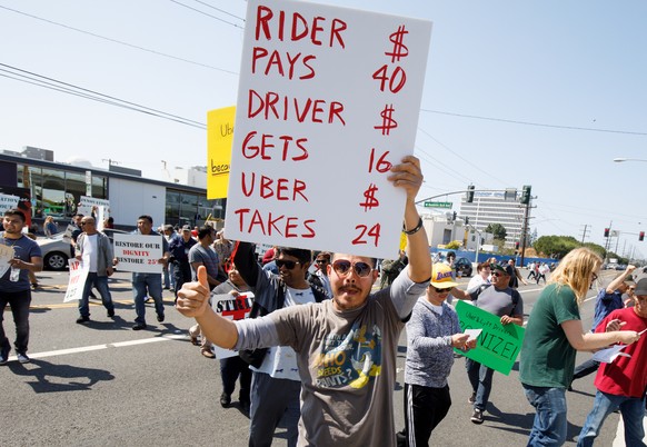 epa07463615 Rideshare drivers from the Los Angeles area protest during a one-day strike outside the Uber Greenlight offices in Redondo Beach, California, USA, 25 March 2019. The 25-hour strike by Ride ...