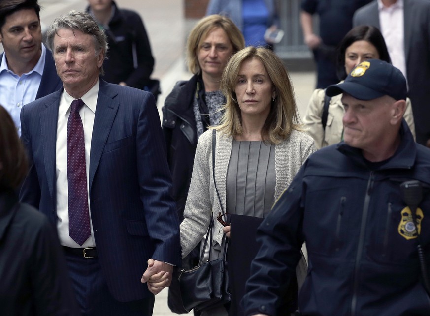 Felicity Huffman, center, departs federal court with her brother Moore Huffman Jr., left, Monday, May 13, 2019, in Boston, where she pleaded guilty to charges in a nationwide college admissions briber ...