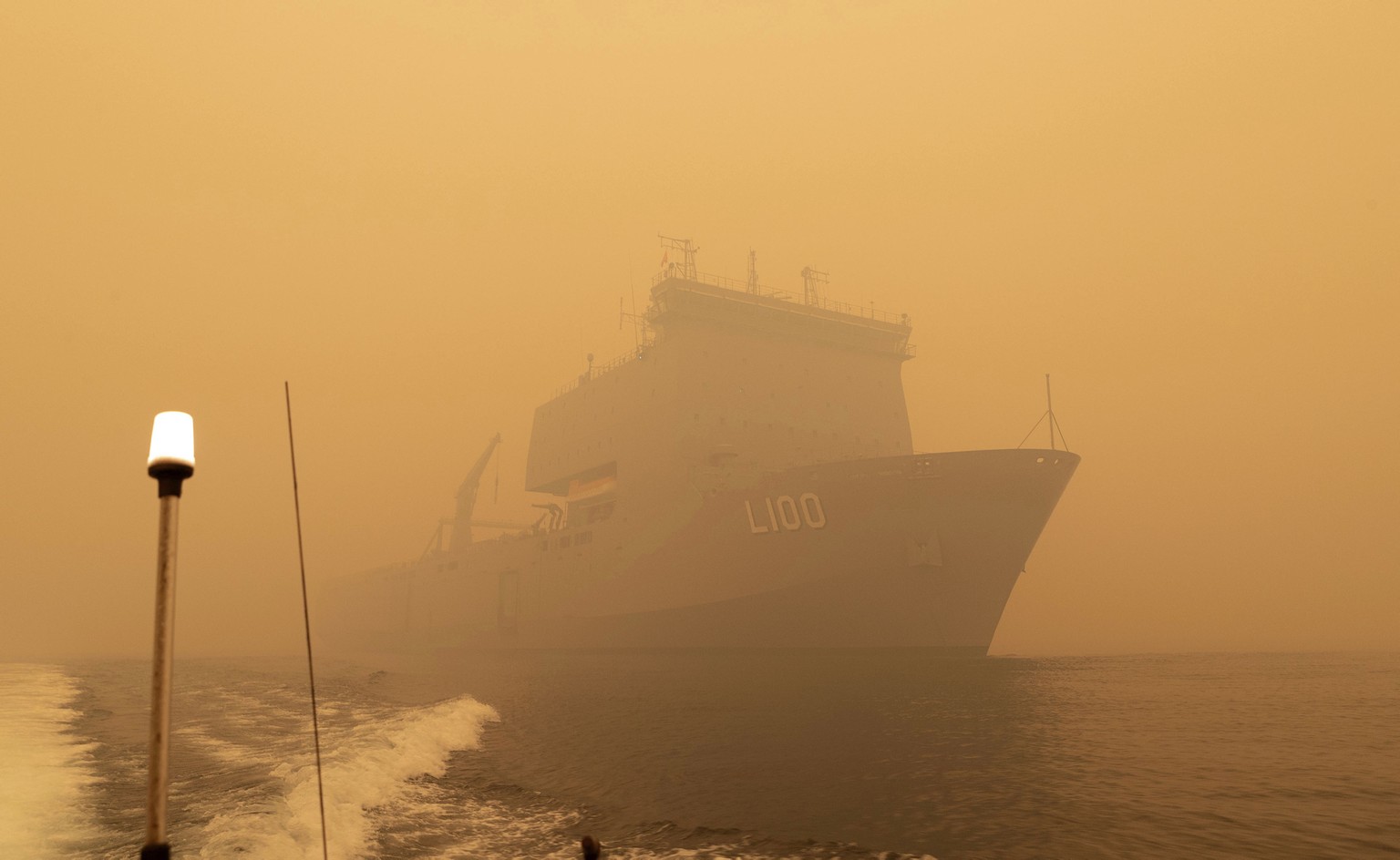 In this photo released and taken Jan. 2, 2020, by the Australian Department of Defense, the HMAS Choules sails off the coast of Mallacoota, Victoria to supply support to people cut off by bush fires.  ...